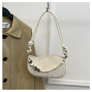 Detail of cream white shoulder bag featuring pearl heart chain and marble texture