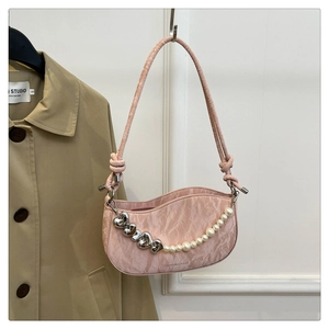 Detail of pink pleated underarm bag with silver heart charms and pearl chain strap