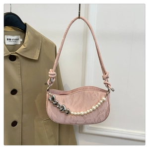 Detailed view of pink crescent underarm bag with pearl chain and heart metal pendants