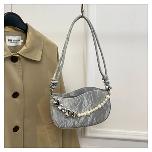 Detail of silver pleated shoulder bag with white pearl chain and metal heart charms