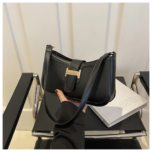 Close-up of black crescent shoulder bag with golden H-shaped metal buckle detail