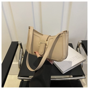 Chic beige envelope shoulder bag with gold buckle displayed in a luxury home setting