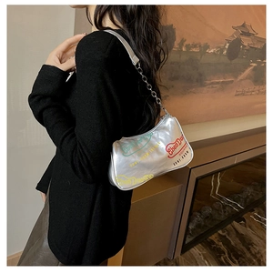 Dettaglio borsa a mezzaluna argento con stampa colorata e tracolla a catena su modella