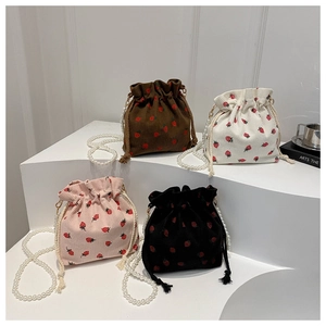 Detail of strawberry corduroy bucket bags in four colors with pearl beaded straps