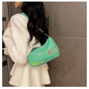 Dettaglio borsa a mezzaluna verde menta con stampa graffiti e tracolla a catena chic