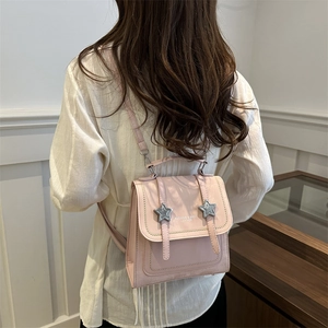 Pink vintage leather backpack with star metal buckles and adjustable straps shown on model