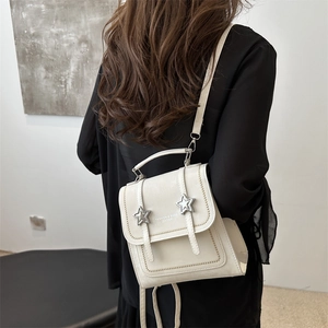 Chic white mini leather backpack for women featuring stylish star-shaped metal buckles