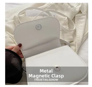 Detailed close-up of white PU leather bag featuring a secure metal magnetic snap closure