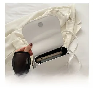Internal view of a white crescent bag showing storage space for a smartphone and wallet