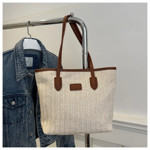 Détail du sac fourre-tout en paille tressée avec bordure et anses en cuir marron