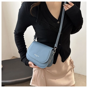 Detail of light blue PU leather crossbody bag with silver Fashion Trend lettering