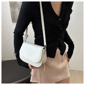 Close-up of white crescent crossbody bag with adjustable strap and Fashion Trend logo