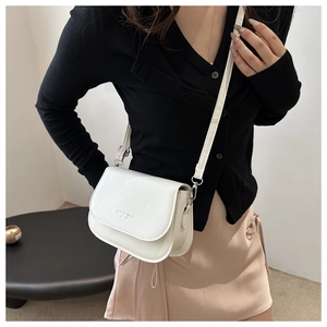 Detailed view of the white PU leather crossbody bag worn by a model in a modern style