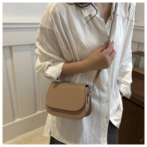 Detail view of khaki saddle bag with Fashion Trend lettering and silver hardware