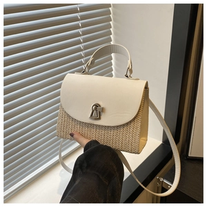 Detail of a straw patchwork handbag with a silver metal twist lock and smooth PU flap