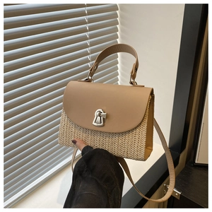 Detail of hand-woven straw texture and khaki leather flap with silver metal twist lock