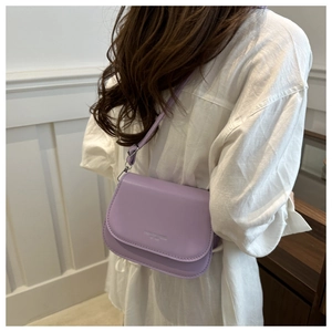 Detail view of purple matte leather crossbody bag with silver hardware on a model