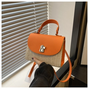 Detail of orange PU flap and beige straw texture on a square crossbody summer bag