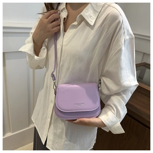 Detail of lavender saddle bag with embossed 'Fashion Trend' text and silver hardware