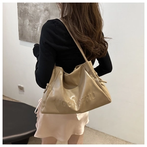 Detail view of khaki pleated tote bag with WGONGZHU embossing and decorative side drawstrings