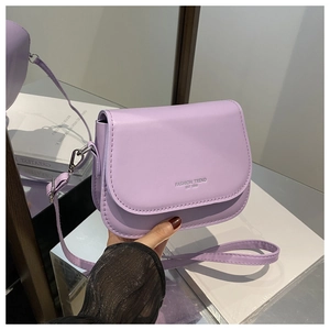 Detail of lavender purple saddle bag featuring Fashion Trend embossed text and matte PU leather