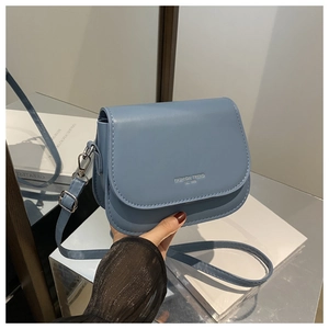 Detail of foggy blue faux leather saddle bag with Fashion Trend embossed lettering