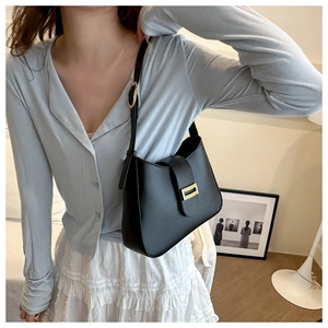 Détail de la bandoulière réglable et boucle dorée sur le sac porté épaule en cuir noir