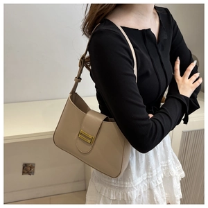 Gros plan du sac sous le bras en cuir kaki avec boucle dorée et bandoulière réglable