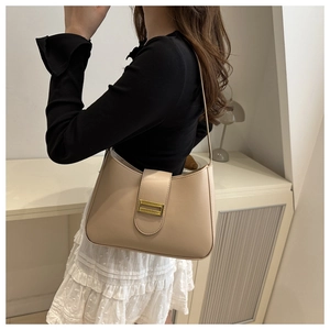 Détail du sac à bandoulière hobo avec rabat et boucle dorée porté par un mannequin