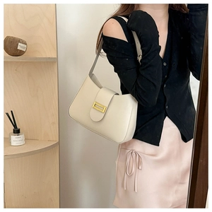 Détail d'un sac à bandoulière en cuir blanc crème avec boucle en métal doré rectangulaire