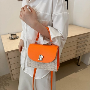 Elegante borsa a tracolla in paglia arancione e beige indossata da una modella
