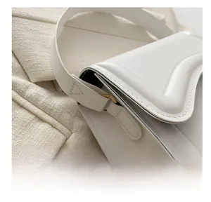 Detailed view of white leather saddle bag showing precise stitching and gold metal rings