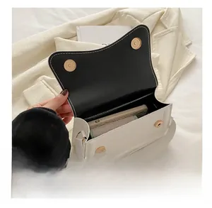 Interior view of white shoulder bag showing black lining and two gold magnetic closures