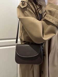 Minimalist vintage dark brown leather crossbody bag styled with a beige trench coat