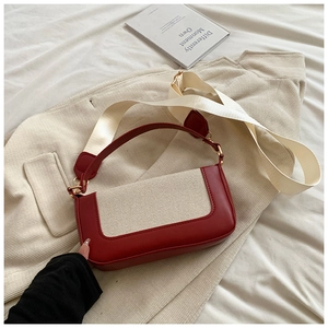 Detail of red leather and beige woven fabric contrast on a retro baguette handbag
