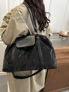 Elegant black oversized tote bag with wrinkled texture and vegan leather straps