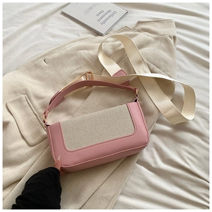 Close-up of pink square bag with cream mesh panel and wide woven shoulder strap