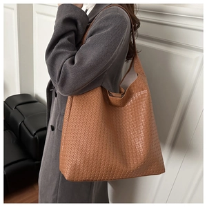 Detail of a brown woven hobo bag showing the classic intrecciato texture and soft leather