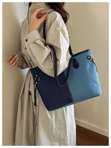 Close-up of contrast denim patchwork tote bag with leather straps and metal hardware