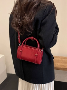 Retro red leather handbag with fashion lettering shown on model with black coat