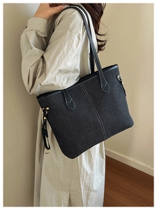 Détails du sac fourre-tout en denim gris foncé avec coutures blanches et anses en cuir