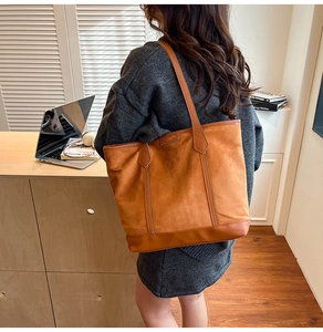 Brown suede tote bag shown on shoulder in a minimalist and cozy lifestyle setting
