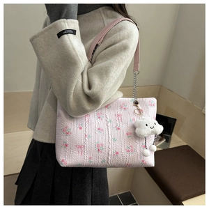 Detail of pink floral shoulder bag with quilting and silver chain strap plus plush charm