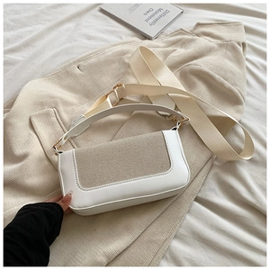 Detail of contrasting leather and woven texture on a minimalist beige crossbody bag