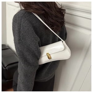 Détail du sac sous le bras en cuir verni blanc avec boucle tournante dorée chic