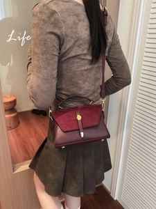 Sac à main bordeaux en cuir mat avec bandoulière réglable dans une scène de vie