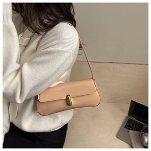 Détail du sac baguette en cuir verni beige clair avec une boucle dorée de style rétro