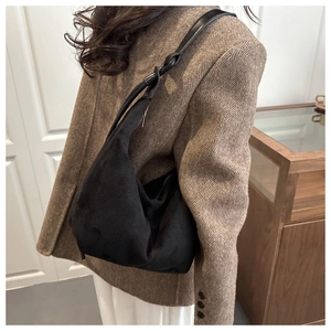 Detail of minimalist black matte hobo bag with sleek shoulder strap and soft texture