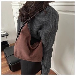 Deep brown suede hobo bag shown from a back perspective to highlight size and natural drape