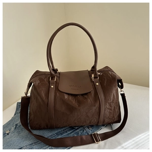 Détail du sac de voyage marron foncé avec tissu texturé et poche avant à rabat